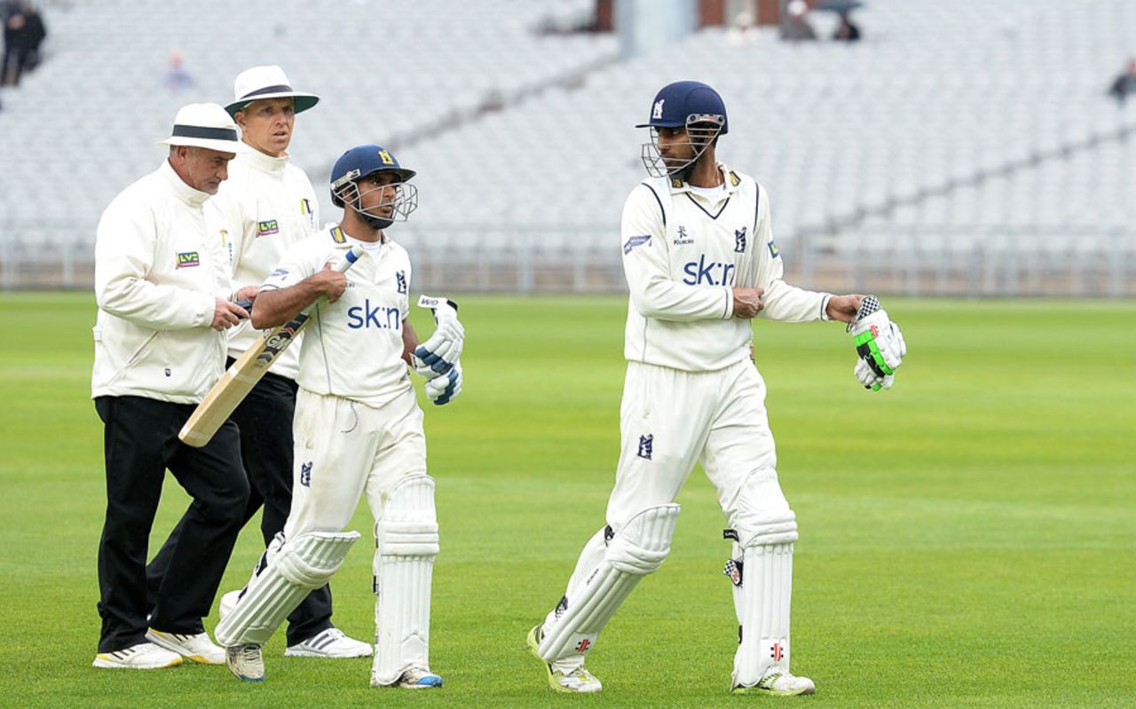 Ateeq Javid and Varun Chopra head off after the umpires halted play due to bad light, Lancashire v Warwickshire, County Championship, Division One, Old Trafford, 4th day, April 23, 2014