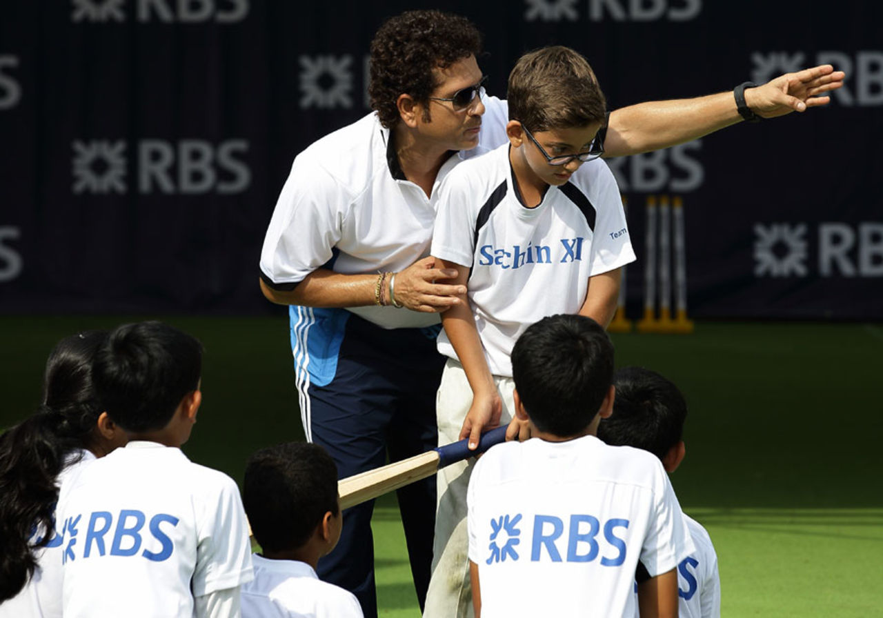 Hit in the V: Sachin Tendulkar teaches batting to a young boy, Singapore, June 3, 2014