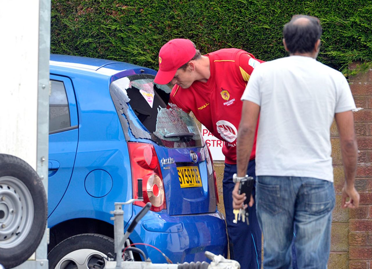 A player retrieves a ball from a car after its rear windshield was broken by a a six hit by Con de Lange, Reivers v Highlanders, North Sea Pro T20 Series, Dumfries, June 2, 2014