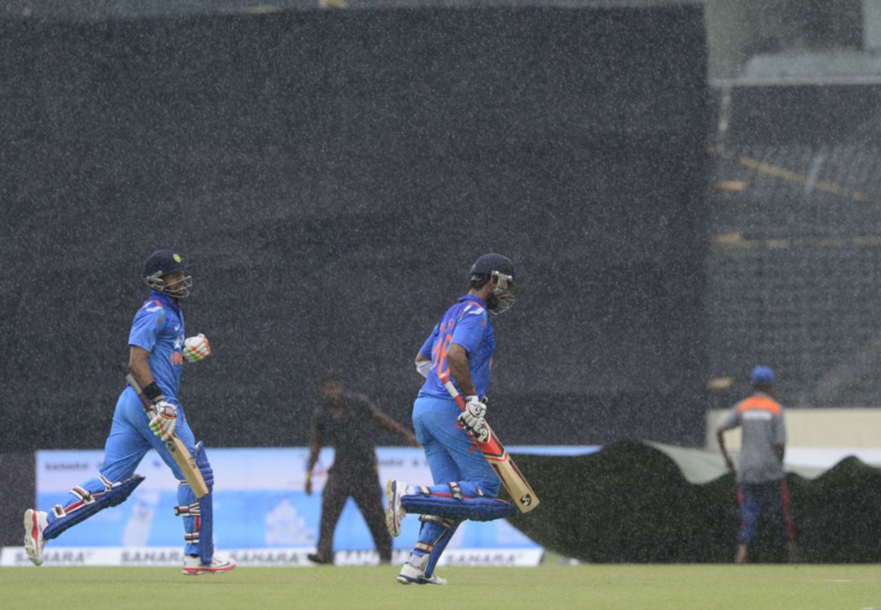 Manoj Tiwary and Cheteshwar Pujara walk off the field as rain falls, Bangladesh v India, 3rd ODI, Mirpur, June 19, 2014
