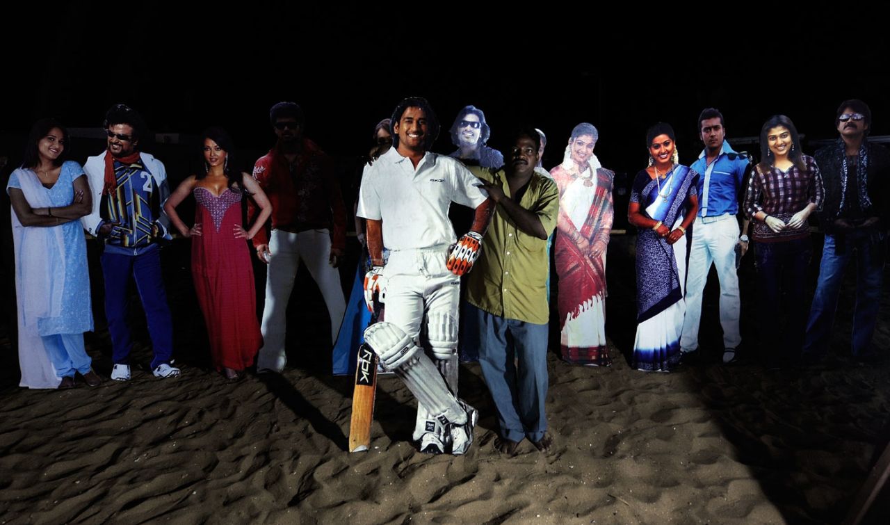 A man holds up a life-size cutout of MS Dhoni on Marina beach, Chennai, March 3, 2011