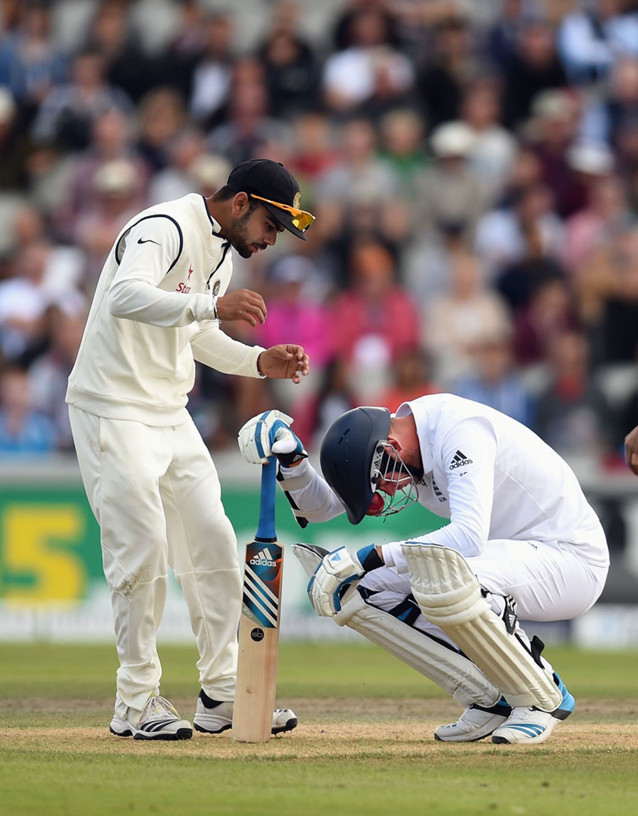 A concerned Virat Kohli rushes up to Stuart Broad after a Varun Aaron bouncer sneaked between the grille and peak of his helmet, England v India, 4th Test, Old Trafford, 3rd day, August 9, 2014