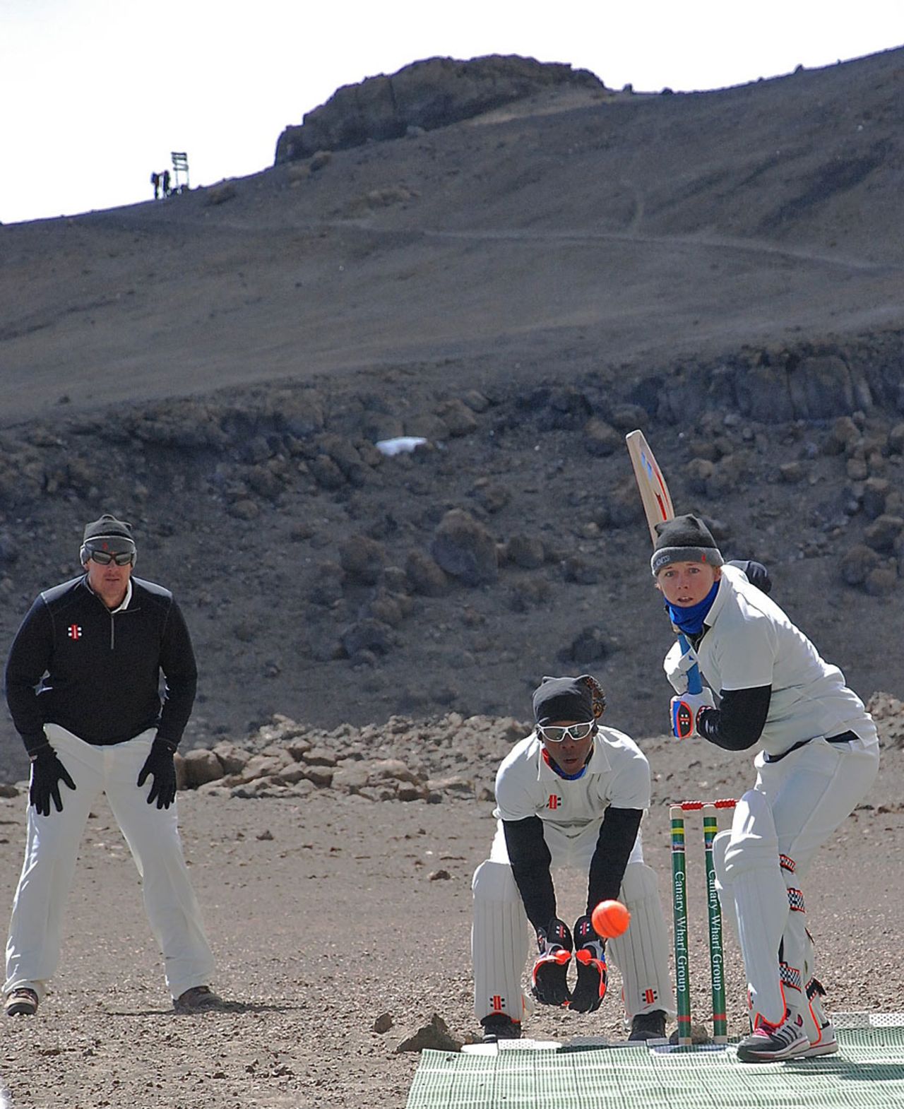 Heather Knight bats and Ashley Giles stands at slip during the cricket match on Kilimanjaro, Tanzania, September 26, 2014