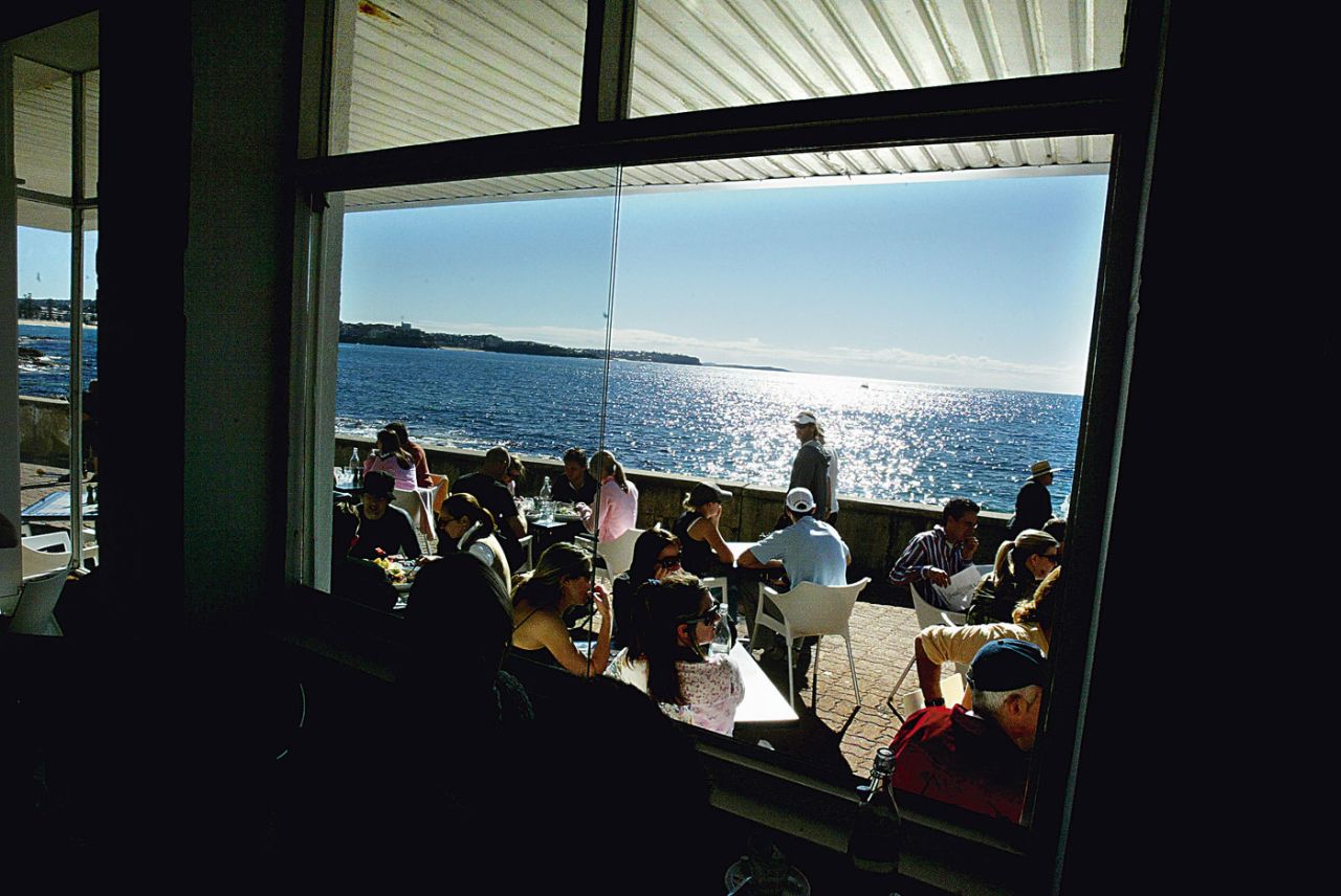 People eat at a restaurant at Shelly Beach in Manly, near Sydney, July 24, 2005