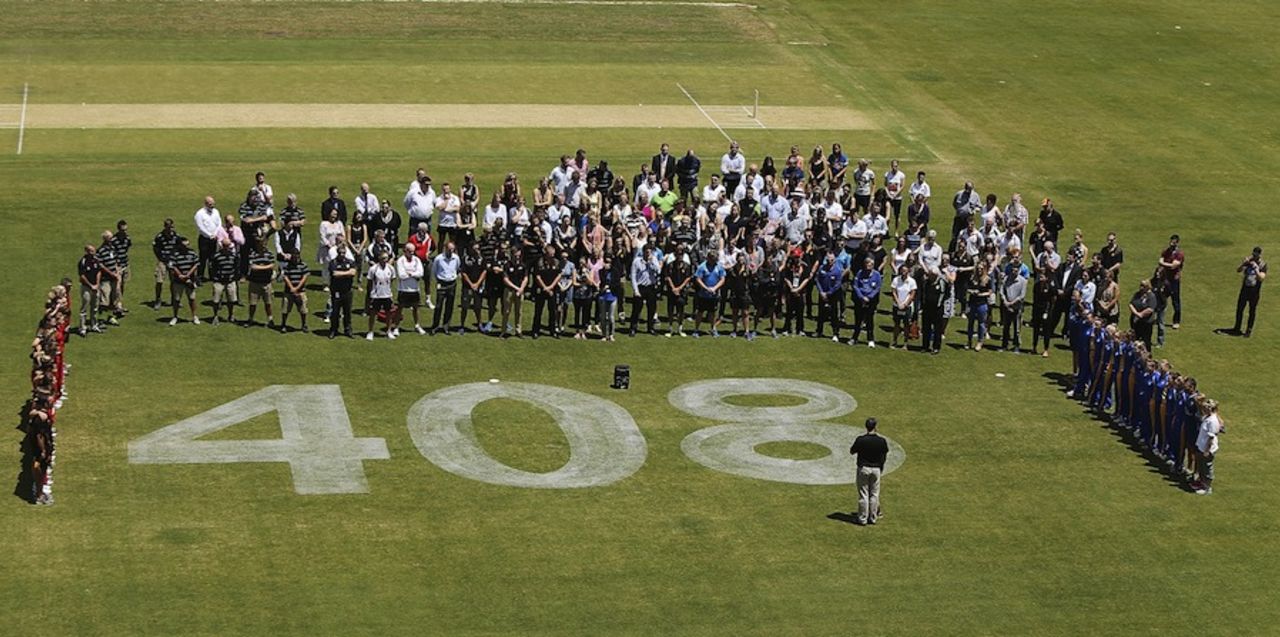 Players and staff pay tribute to Phillip Hughes at a WCNL game with his cap no. painted on the outfield, Adelaide, November 28, 2014