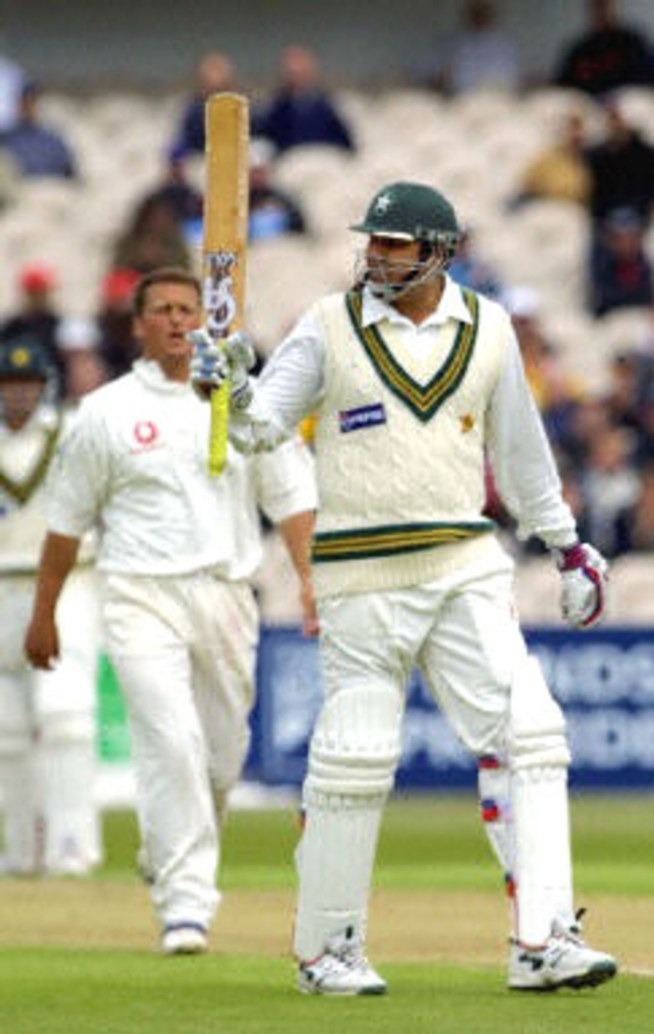 Pakistani batsman Inzamam-ul-Haq celebrates a half century as he is watched by Darren Gough, day 1, 2nd Test at Old Trafford, 31 May - 4 June 2001.
