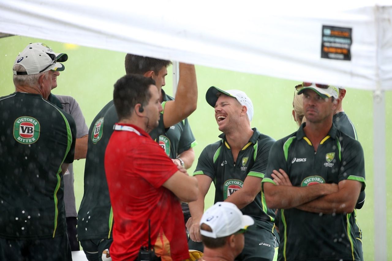 David Warner bursts into laughter while taking shelter under a marquee as it rains at Eden Park, World Cup 2015, Auckland, February 27, 2015