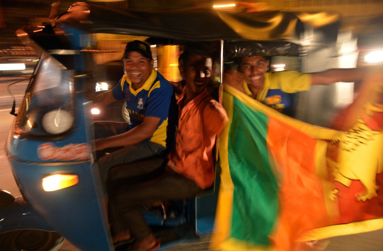 Fans ride in a tuk-tuk, Colombo, April 6, 2014