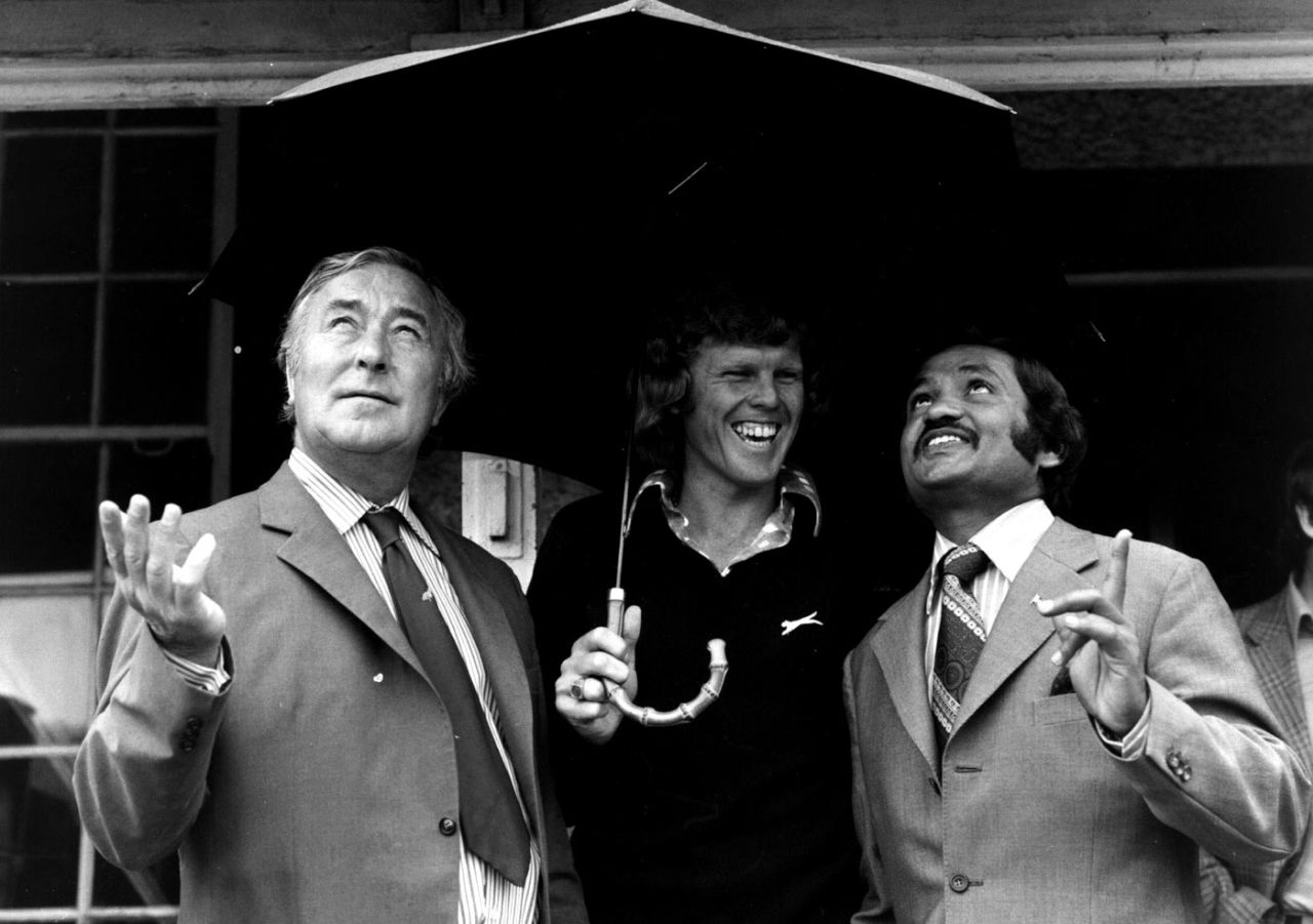 Denis Compton, Barry Richards and Mushtaq Mohammad shelter from the rain during a charity match in London, June 29, 1974