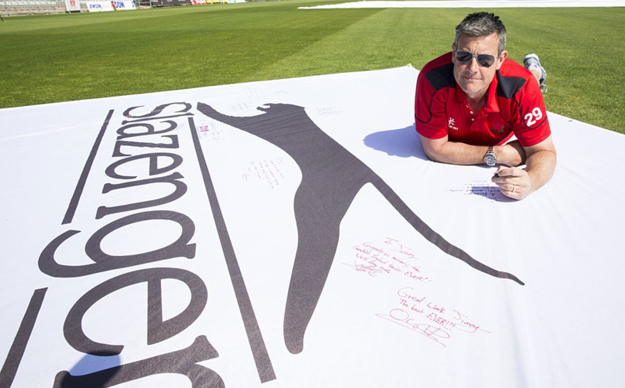 Ashley Giles signs a flag to mark James Anderson's record wicket haul, Old Trafford, April 23, 2015