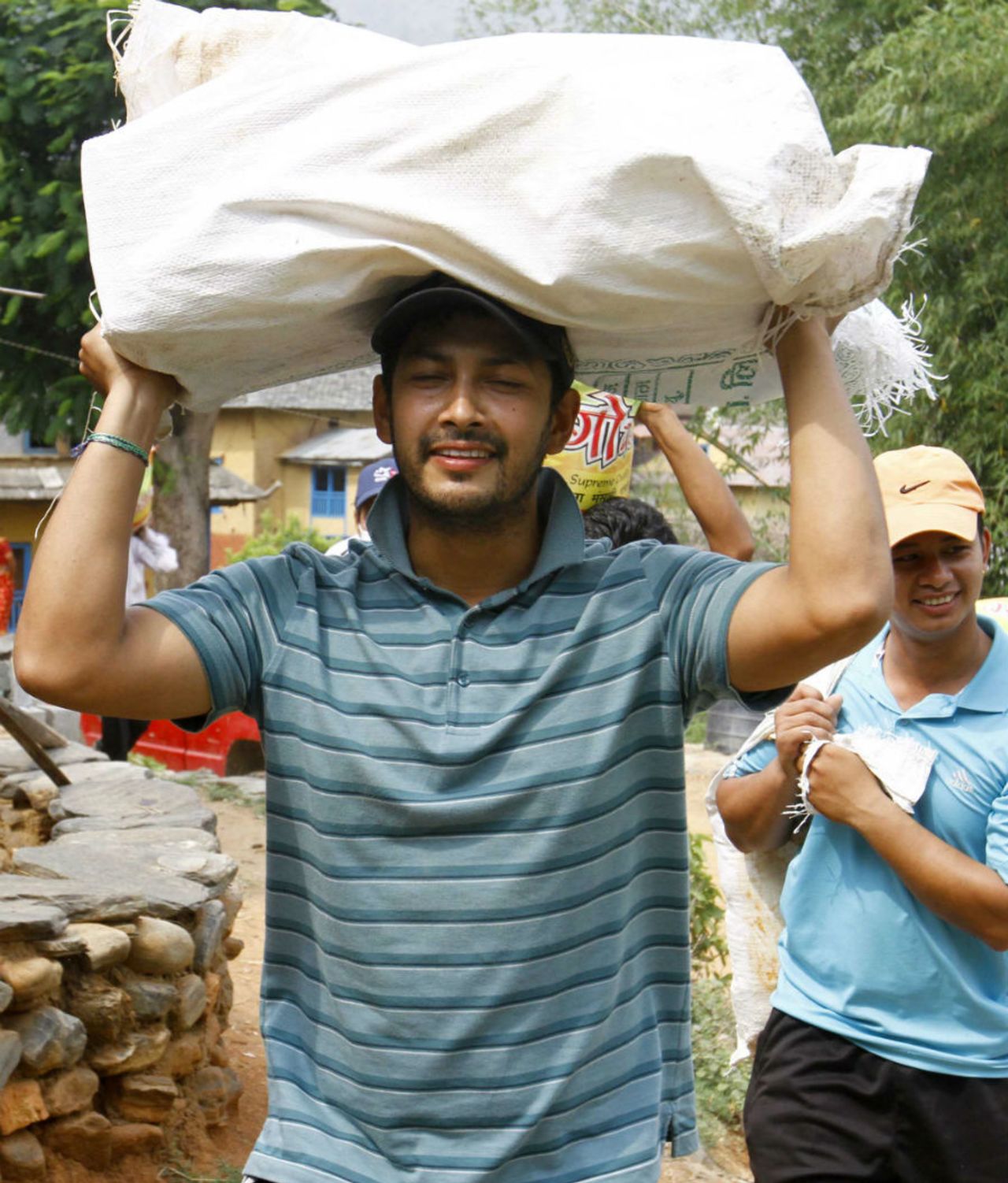 Subash Khakurel, wicket keeper batsman of the Nepal national cricket team carrying relief material to earthquake victims at Baseshwor VDC in Sindhuli on May 7 2015.