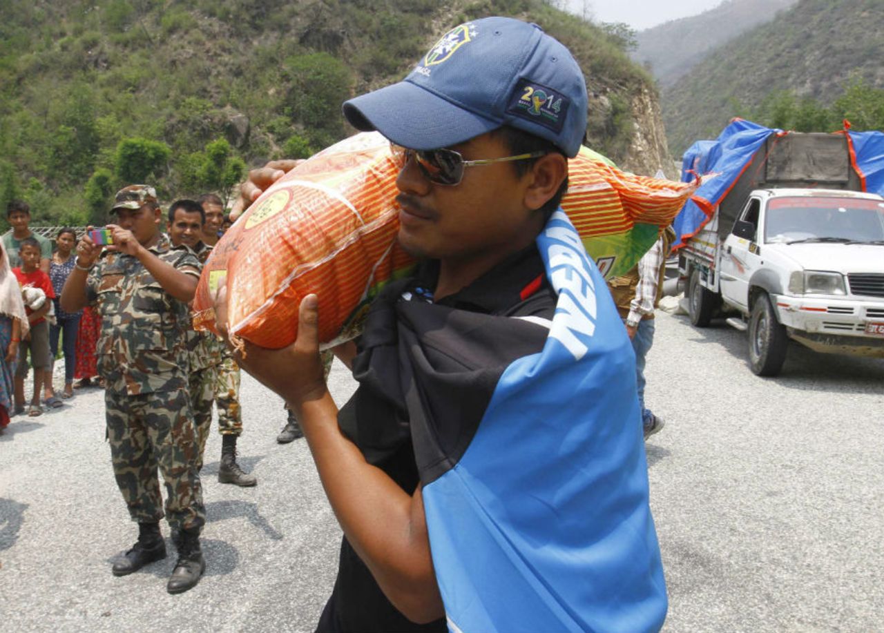 Gyanendra Malla, Vice-Captain of the Nepal national cricket team carrying a sack of rice to be distributed to earthquake victims at Baseshwor VDC in Sindhuli on May 7 2015