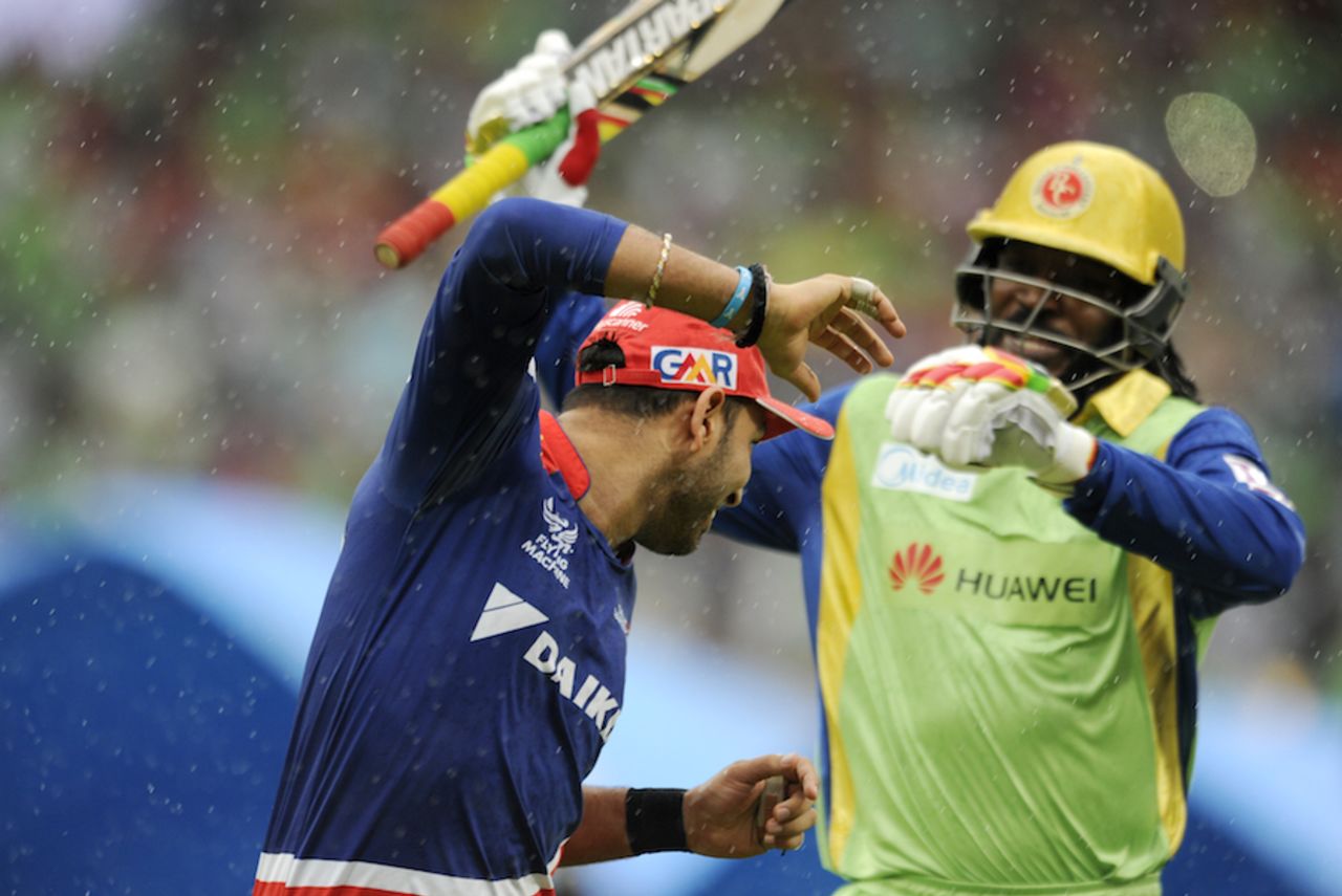 Yuvraj Singh and Chris Gayle share a light moment as the teams leave the field, Royal Challengers Bangalore v Delhi Daredevils, IPL 2015, Bangalore, May 17, 2015