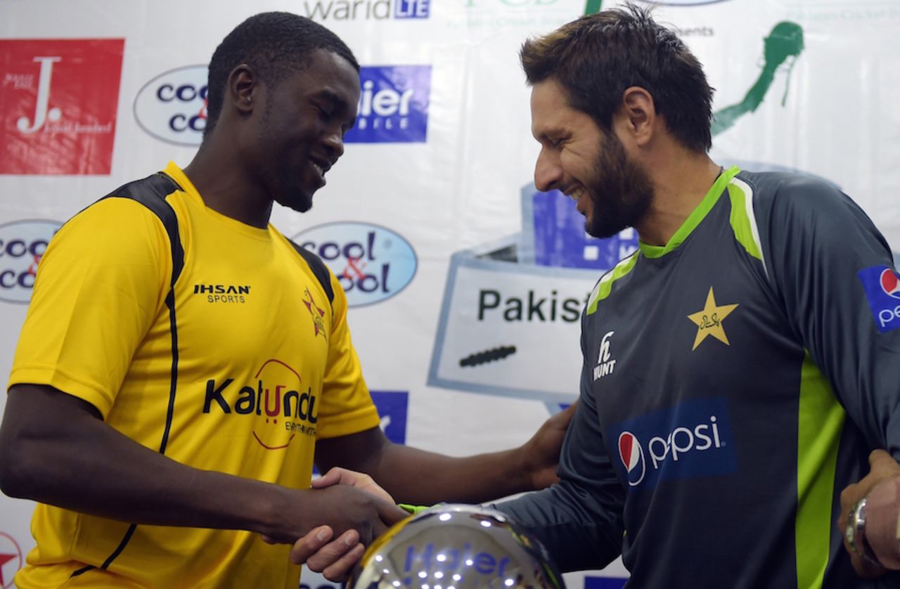 Elton Chigumbura and Shahid Afridi greet each other during the unveiling of the trophy, Lahore, May 21, 2015