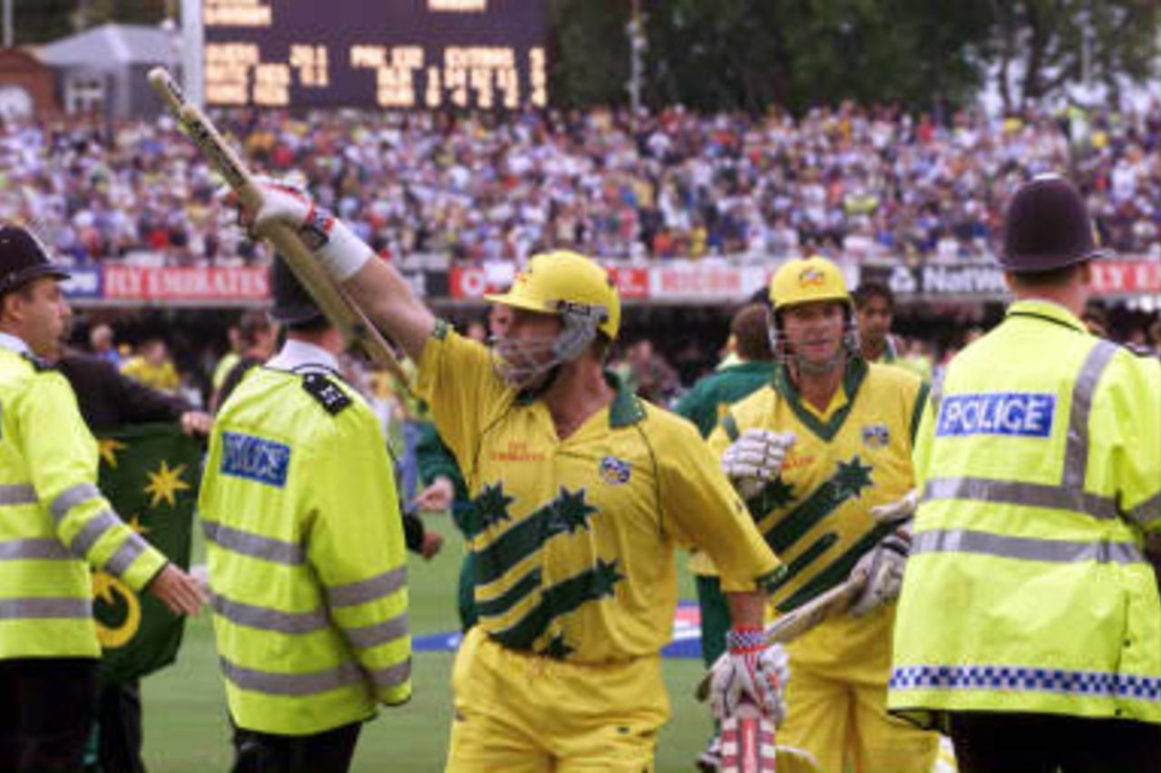 The victorious Australian cricket batsman Mark Waugh carries the stumps off the pitch with teammate Darren Lehmann (Right) after Australia defeated Pakistan by eight wickets in the World Cup final at Lords, 20 June 1999.