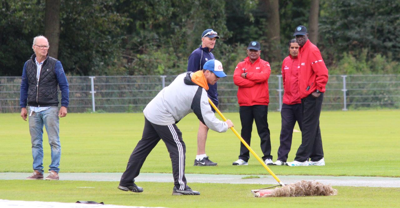 Play is delayed while ground staff tends to wet patches near the 30-yard circle following rain showers, Netherlands v Scotland, WCL Championship, Amstelveen, September 14, 2015