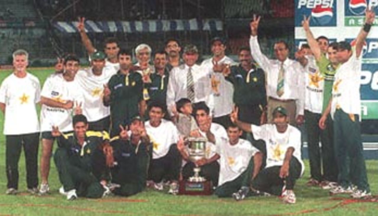 Pakistani players and team officials pose for a photo with the Seventh Asia Cup trophy they won after beating defending champion Sri Lanka by 39 runs in an exciting final match of the limited-overs tournament in Dhaka 07 June 2000. Pakistan, which won all the earlier league matches it played against India, Sri Lanka and host Bangladesh, clinched the Asia Cup for the first time since its introduction in 1986.