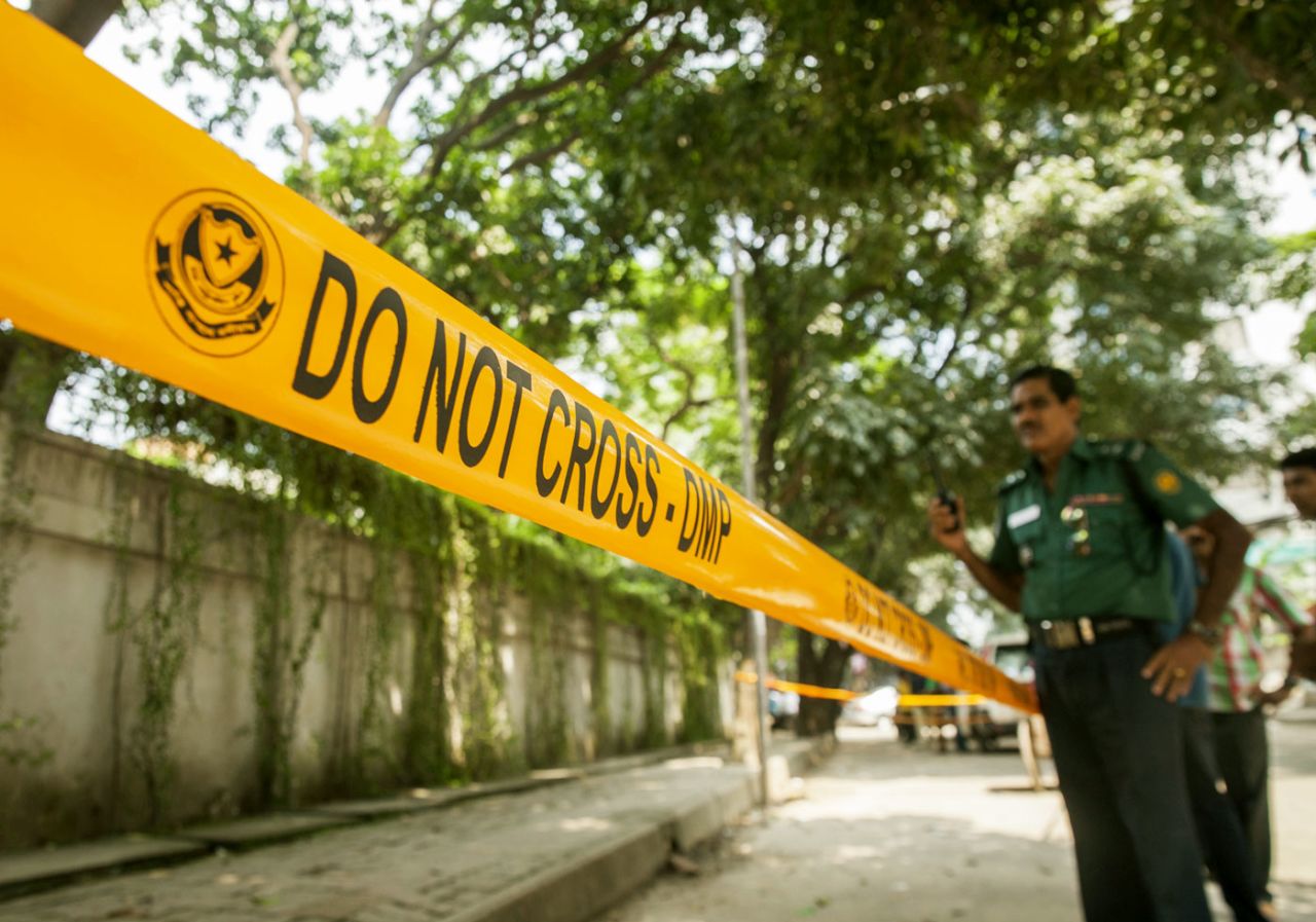 Bangladeshi police officers stand guard at the site where an Italian charity worker was shot to death by attackers in Dhaka, September 29, 2015