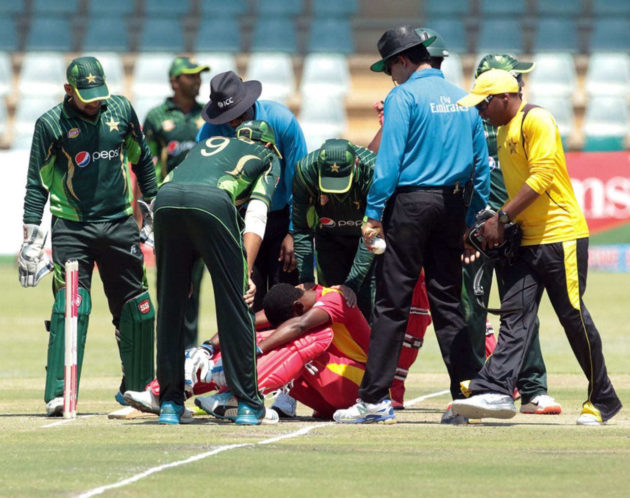 The Pakistan players check on Richmond Mutumbami after he was struck by a bouncer, Zimbabwe v Pakistan, 3rd ODI, Harare, October 5, 2015