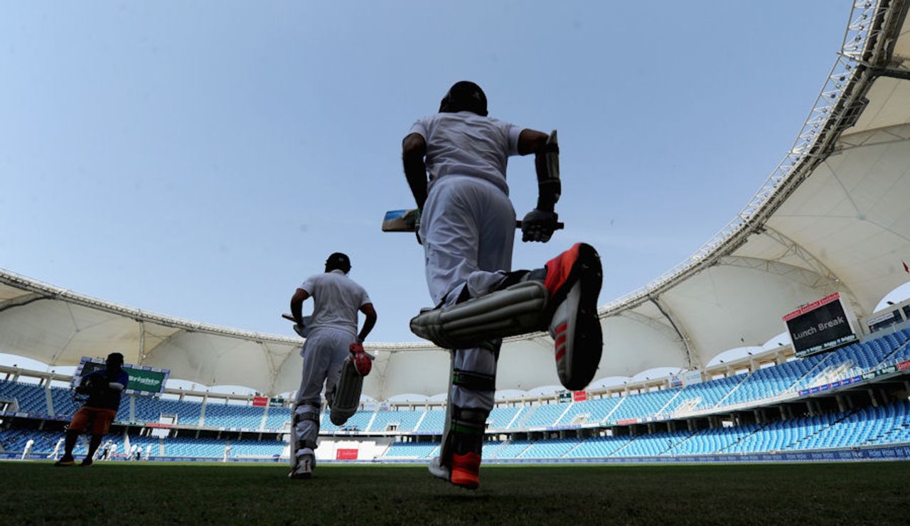 Alastair Cook and Moeen Ali run into a deserted stadium to start England's innings, Pakistan v England, 2nd Test, Dubai, 2nd day, October 23, 2015