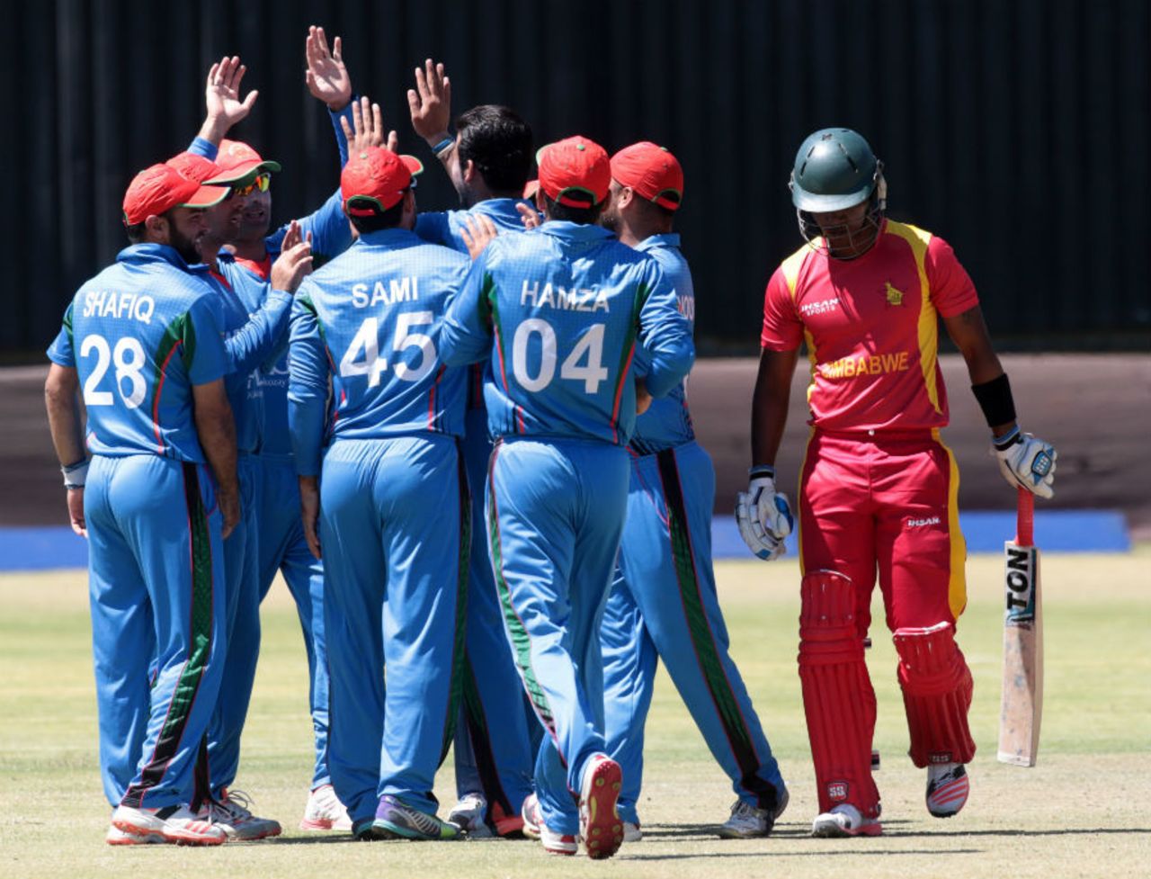 Dawlat Zadran is mobbed by his team-mates after dismissing Chamu Chibhabha, Zimbabwe v Afghanistan, 5th ODI, Bulawayo, October 24, 2015