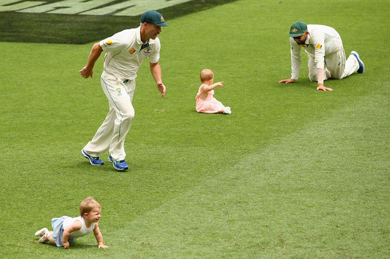 Nathan Lyon and David Warner play with their children after Australia's win at the Gabba, Australia v New Zealand, 1st Test, Brisbane, 5th day, November 9, 2015