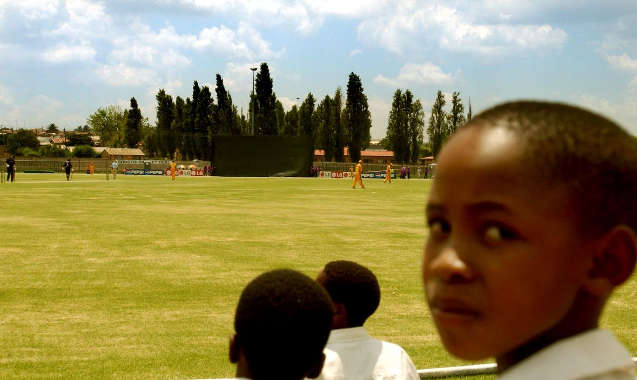 Soweto school children watch the warm up match between New Zealand and Gauteng at Soweto Cricket Oval in Soweto, February 6, 2003