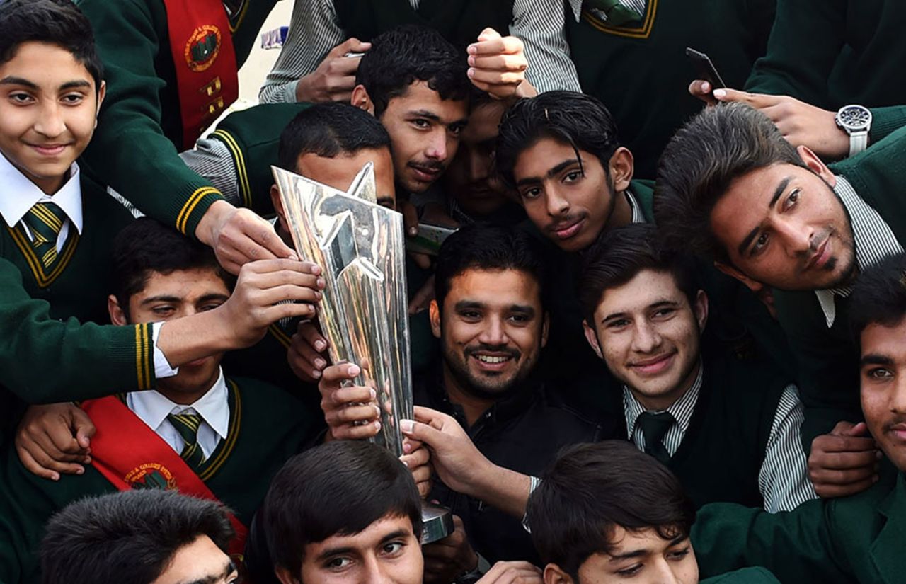 Azhar Ali holds the World T20 trophy while posing with students of the Army Public School, Peshawar, January 11, 2015