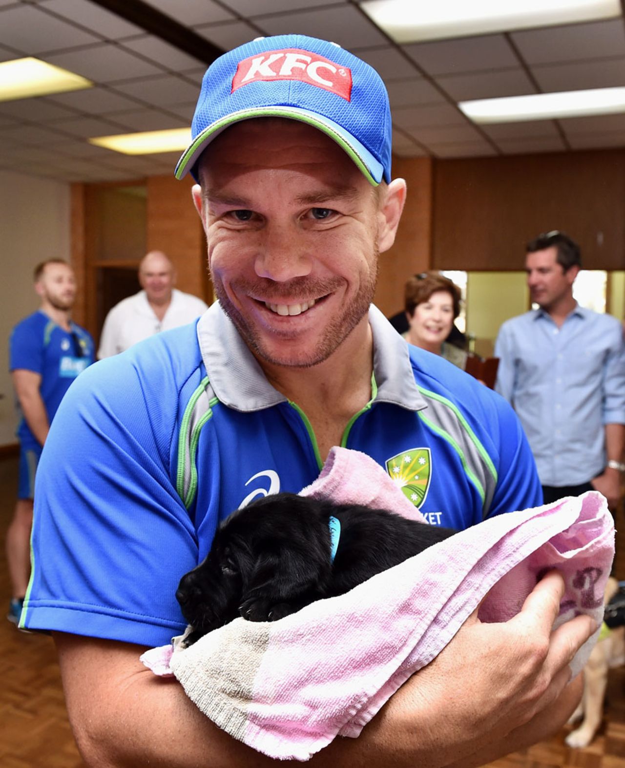 David Warner shows off a puppy guide dog, Adelaide, January 25, 2016