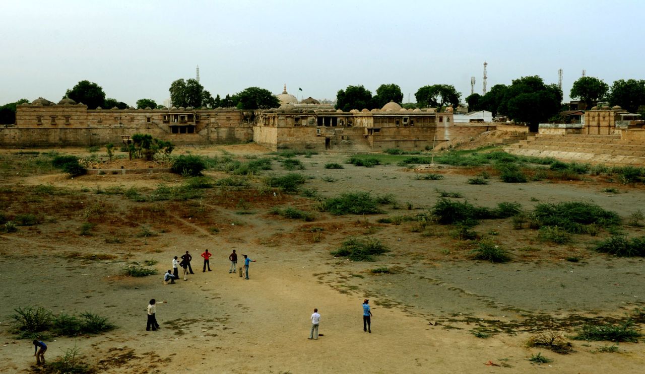 Children play on the dry bed of  Ahmad Sar Lake in Sarkhej Roza, a mosque and tomb complex in a village outside Ahmedabad, April 9, 2010