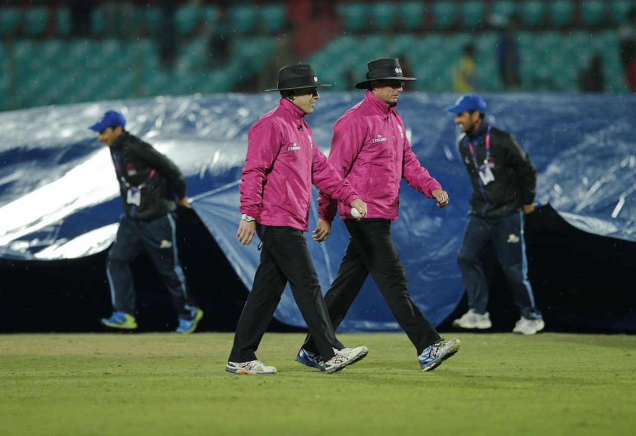 Chris Gaffaney and Rod Tucker leave the field as the covers come on, Bangladesh v Oman, World T20 qualifiers, Group A, Dharamsala, March 13, 2016