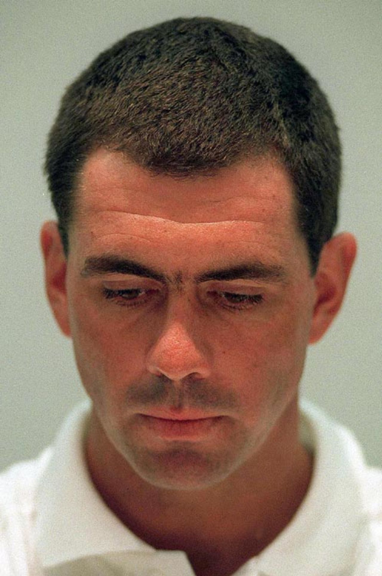 Hansie Cronje, head bowed, faces the media, April 11, 2000