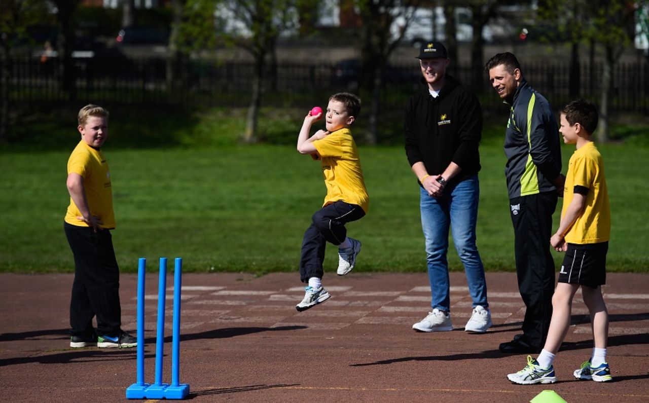 Charlie Darwood from Ravenswood primary school bowls as Ben Stokes and WWE superstar The Miz look on, Newcastle, April 20, 2016