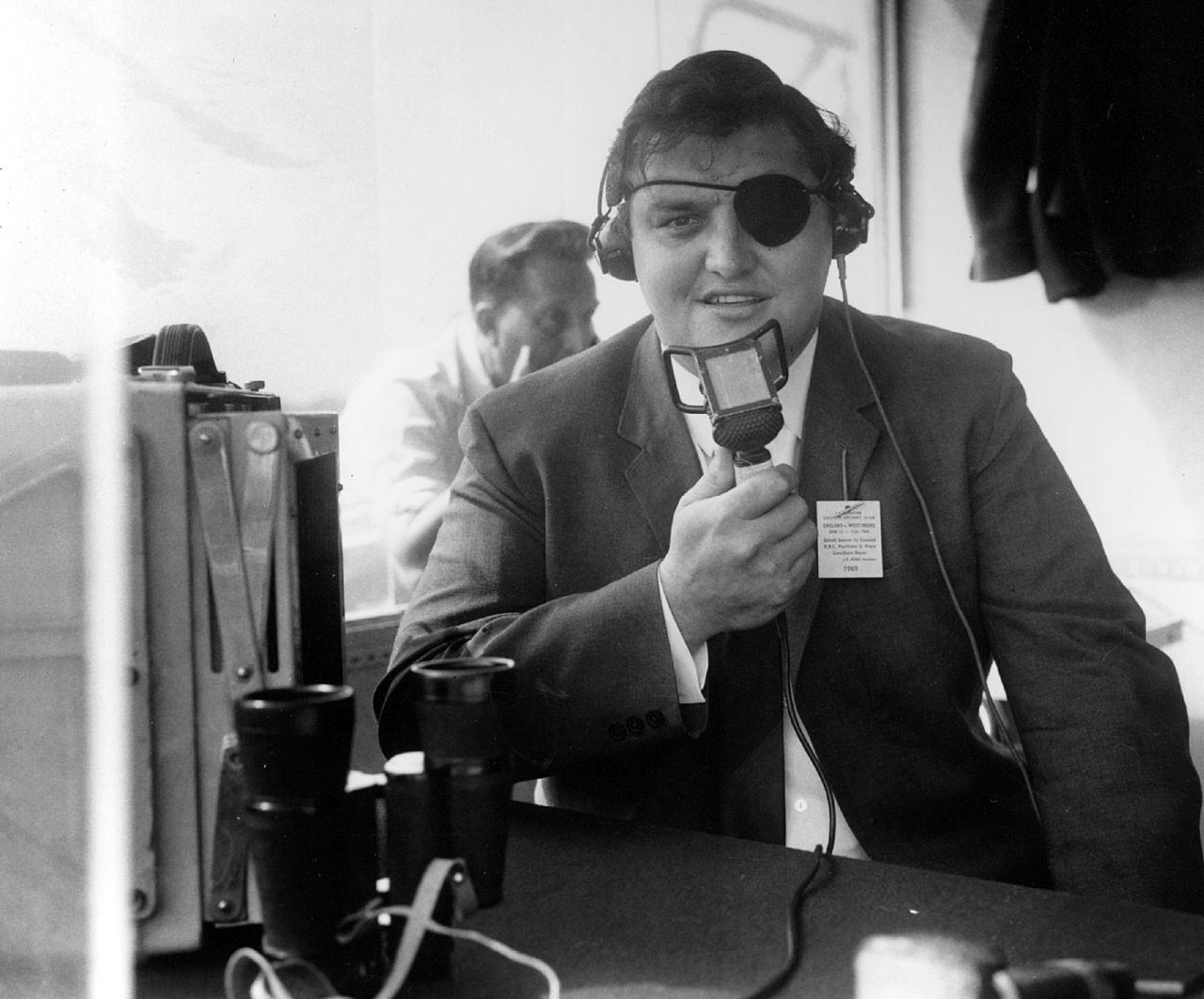 Colin Milburn, wearing an eyepatch after his accident, does commentary for the BBC, Old Trafford, June 12, 1969