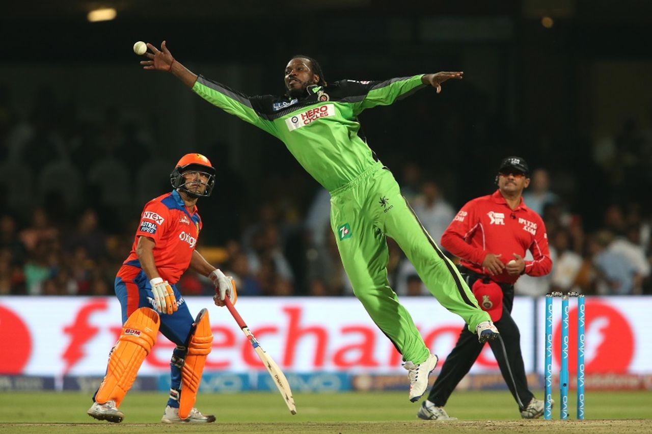 Chris Gayle does a full stretch as he tries to stop the ball off his own bowling, Royal Challengers Bangalore v Gujarat Lions, IPL 2016, Bangalore, May 14, 2016