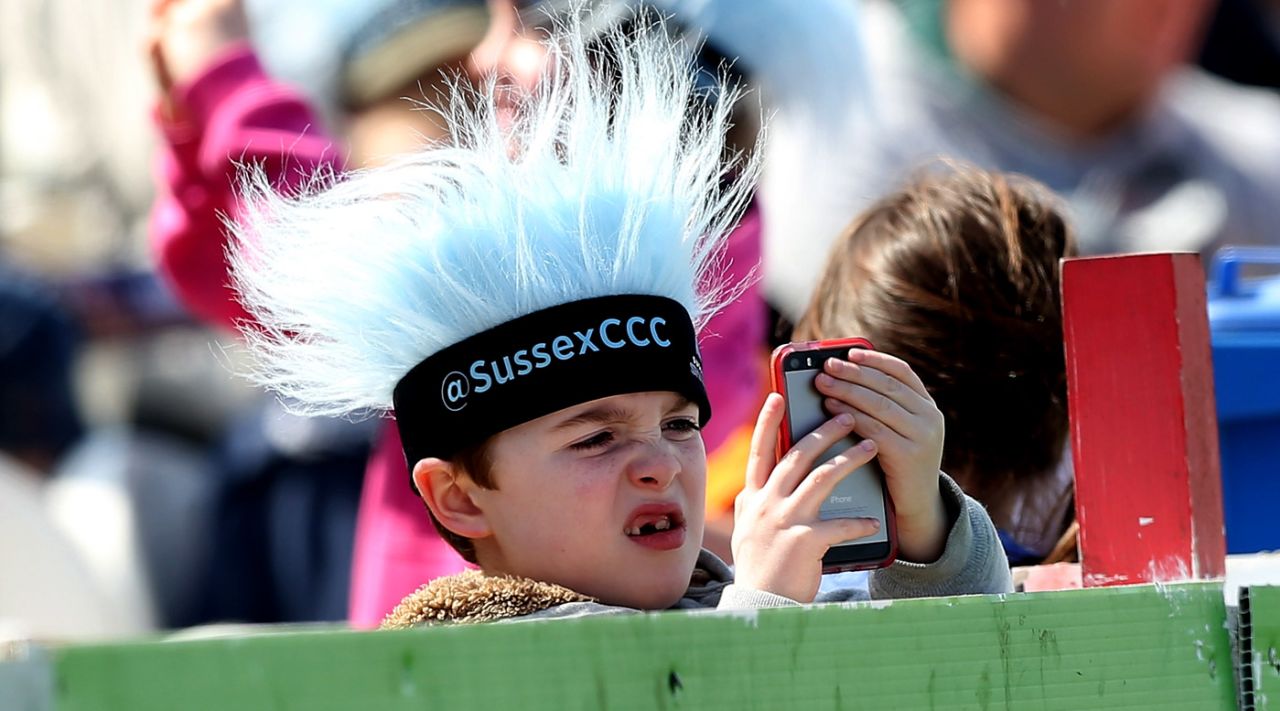 A young fan looks at his phone, Sussex v Gloucestershire, NatWest T20 Blast, South Group, Hove, May 17, 2015