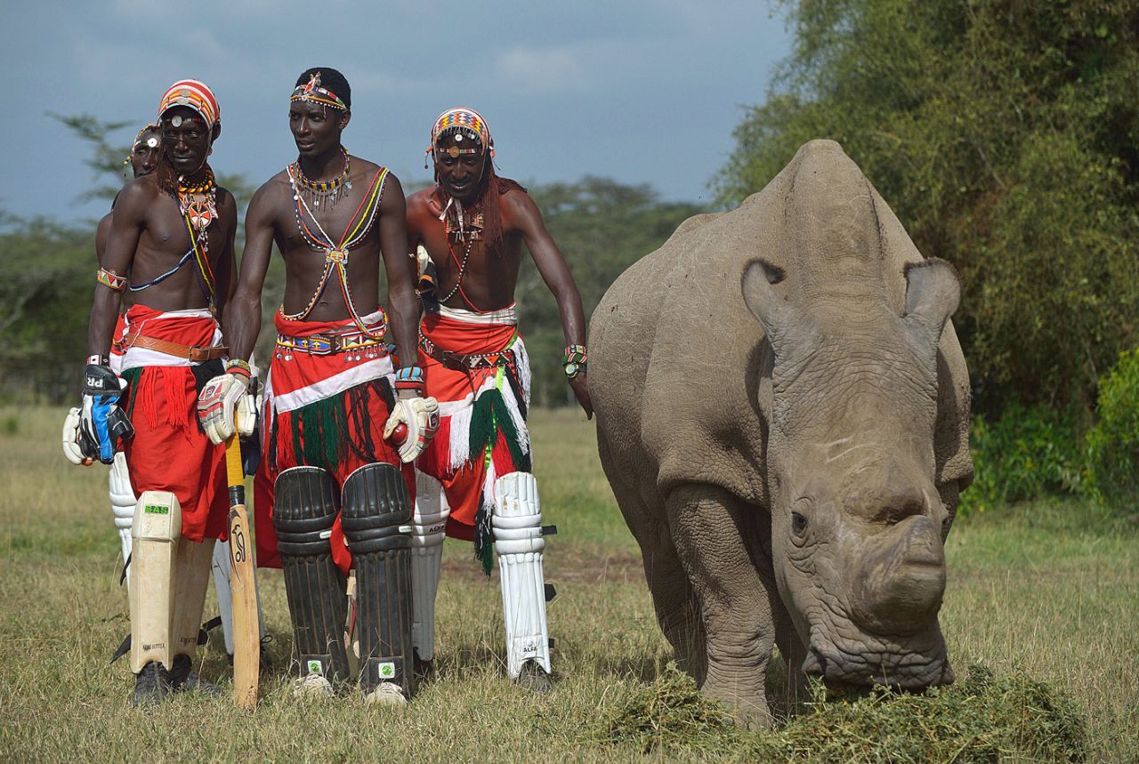 Members of the Maasai Cricket Warrior pose for a photograph next to Sudan, the last male of his sub-species, at the Ol Pejeta conservancy in Kenya, June 14, 2015