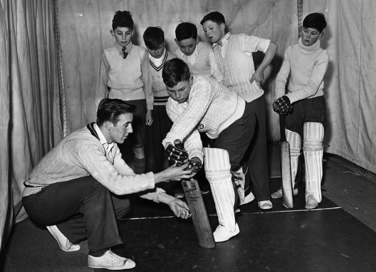 A Middlesex professional shows young boys in London the correct way to hold a bat, February 6, 1956