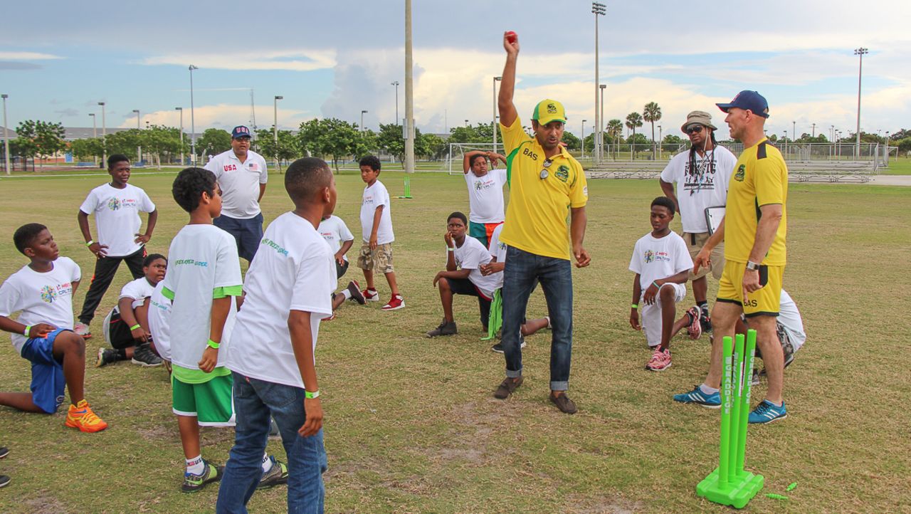 Kumar Sangakkara teaches local Florida kids how to bowl during a clinic put on by Jamaica Tallawahs, Florida, July 22, 2016