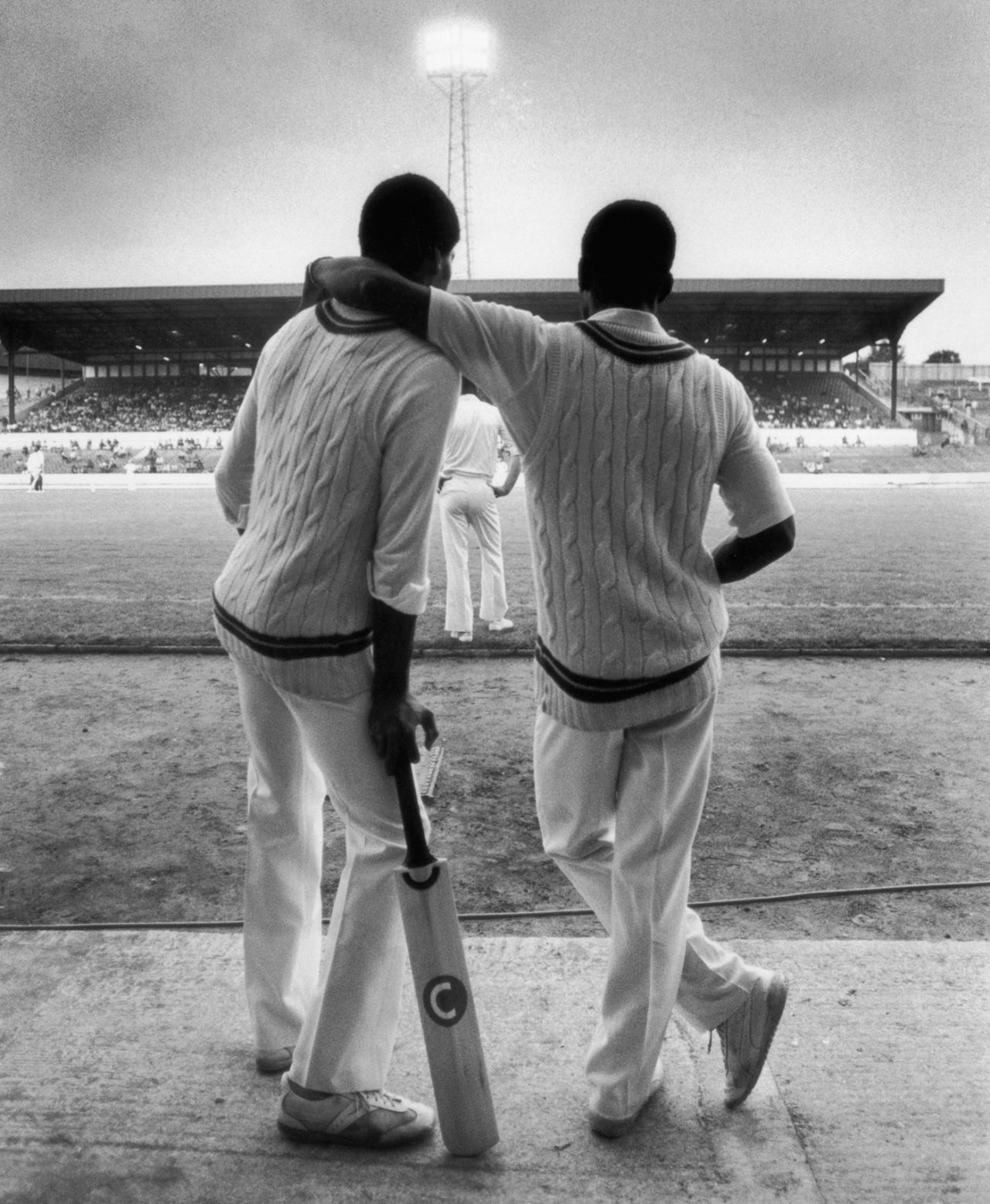 Two players look out over the pitch during the floodlit match between Essex and West Indies, Stamford Bridge, August 14, 1980