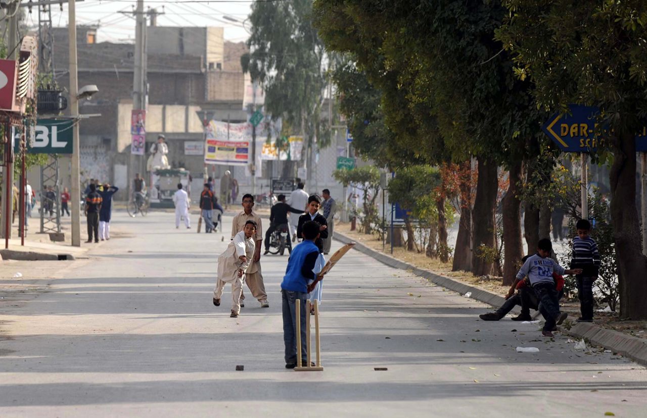 Kids play cricket in a street during a curfew in Rawalpindi, November 16, 2013