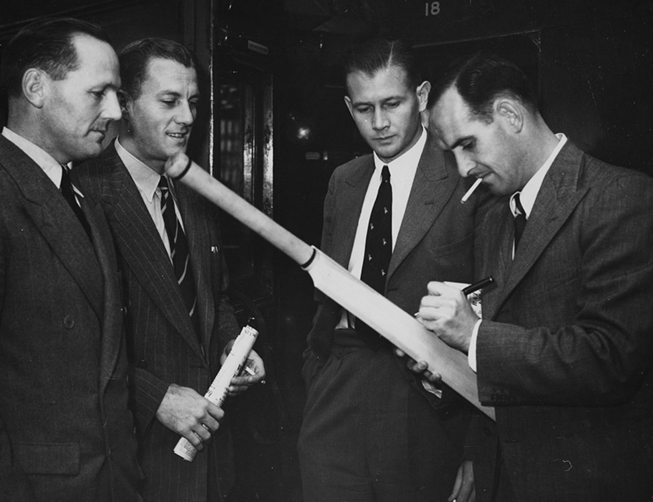 South Africa cricketers (L-R) Ken Viljoen, Athol Rowan, Lindsay Tuckett and Jack Plimsoll sign a bat, London, September 11, 1947