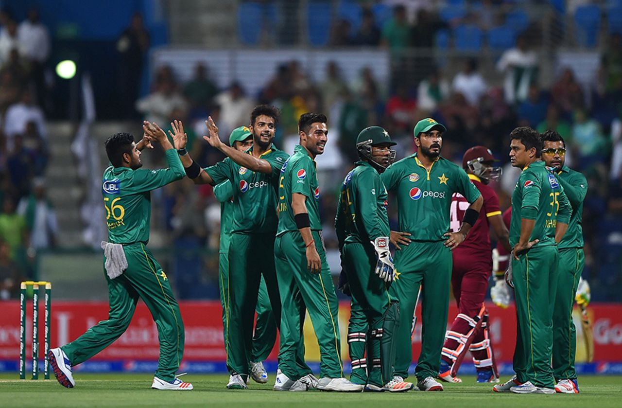 The Pakistan players gather around Imad Wasim to celebrate Dwayne Bravo's wicket, Pakistan v West Indies, 3rd T20I, Abu Dhabi, September 27, 2016