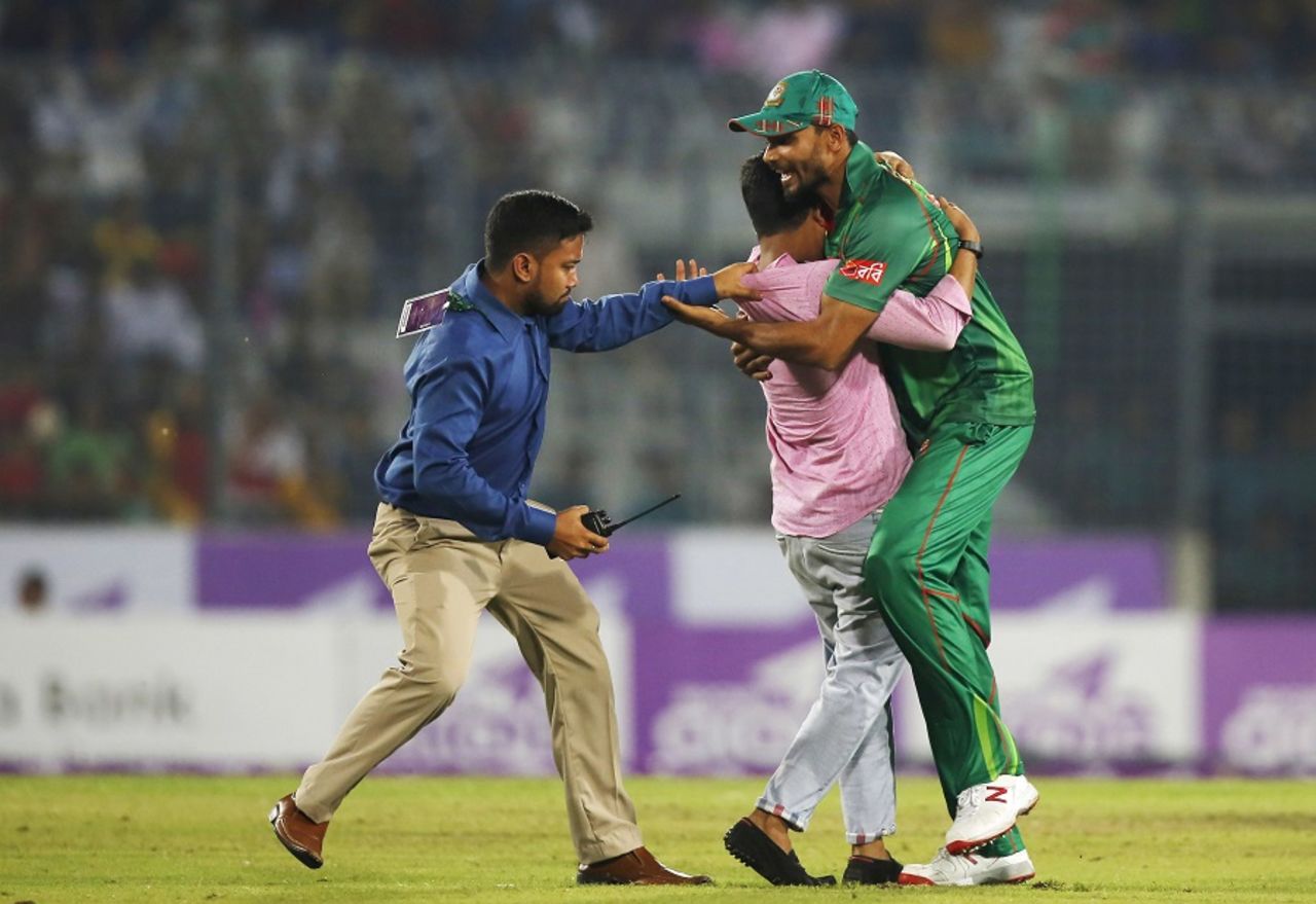 A security official grabs a fan who barges into the field and hugs Mashrafe Mortaza, Bangladesh v Afghanistan, 3rd ODI, Mirpur, October 1, 2016