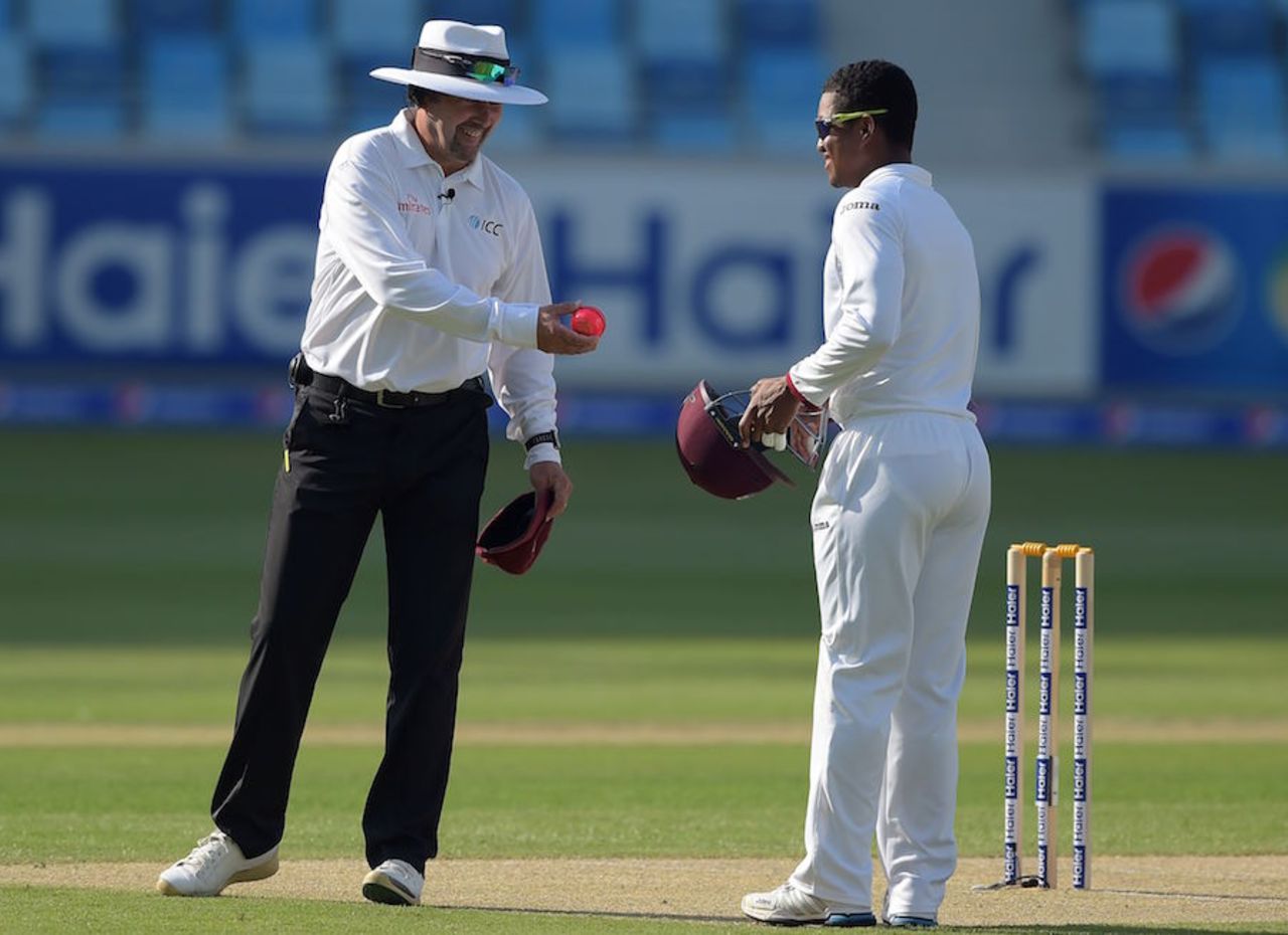 Wanna taste? Richard Illingworth hands the pink ball to Leon Johnson, Pakistan v West Indies, 1st Test, Dubai, 1st day, October 13, 2016