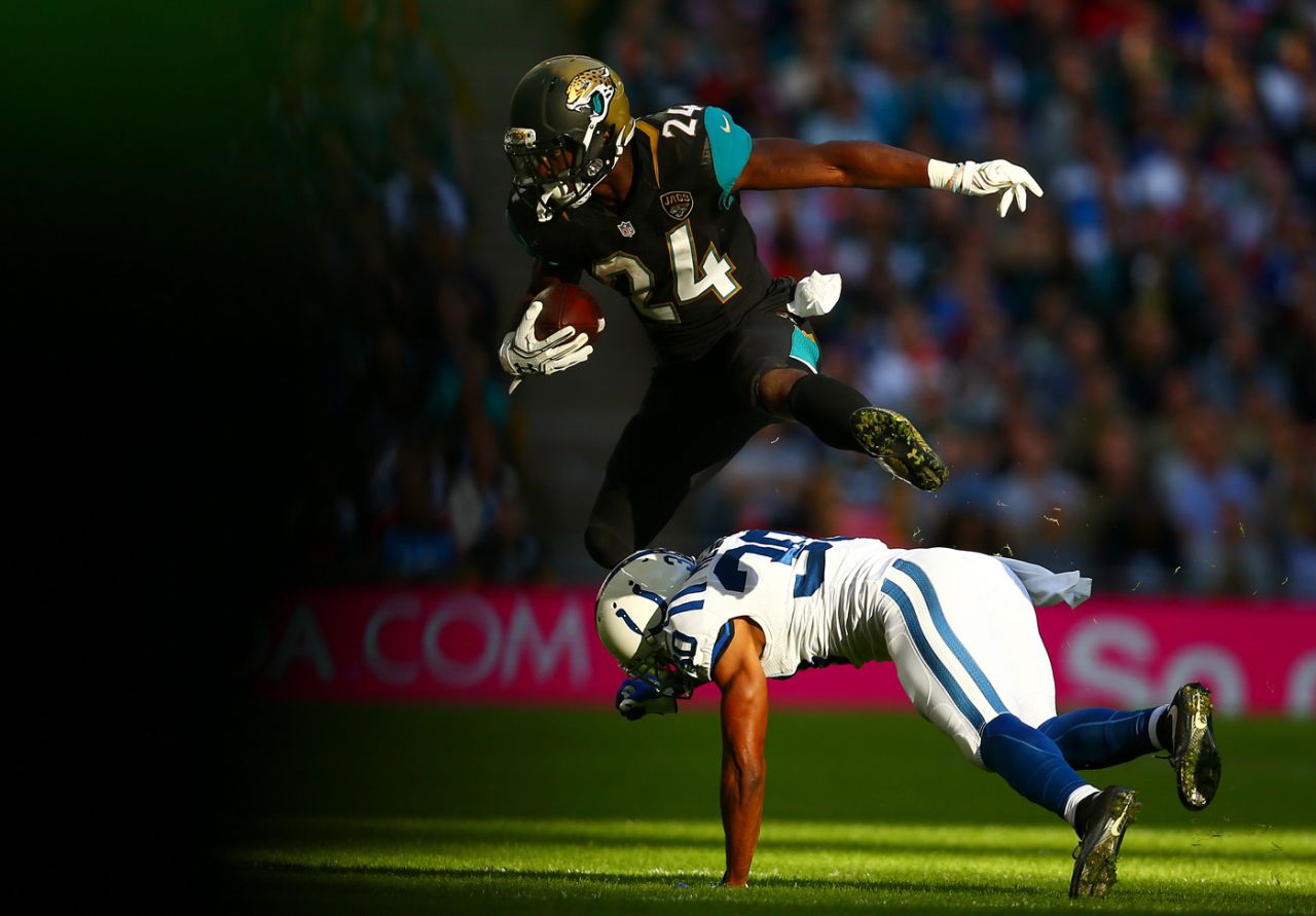 TJ Yeldon of the Jacksonville Jaguars leaps over Rashaan Melvin of the Indianapolis Colts during the NFL game at Wembley Stadium, October 2, 2016