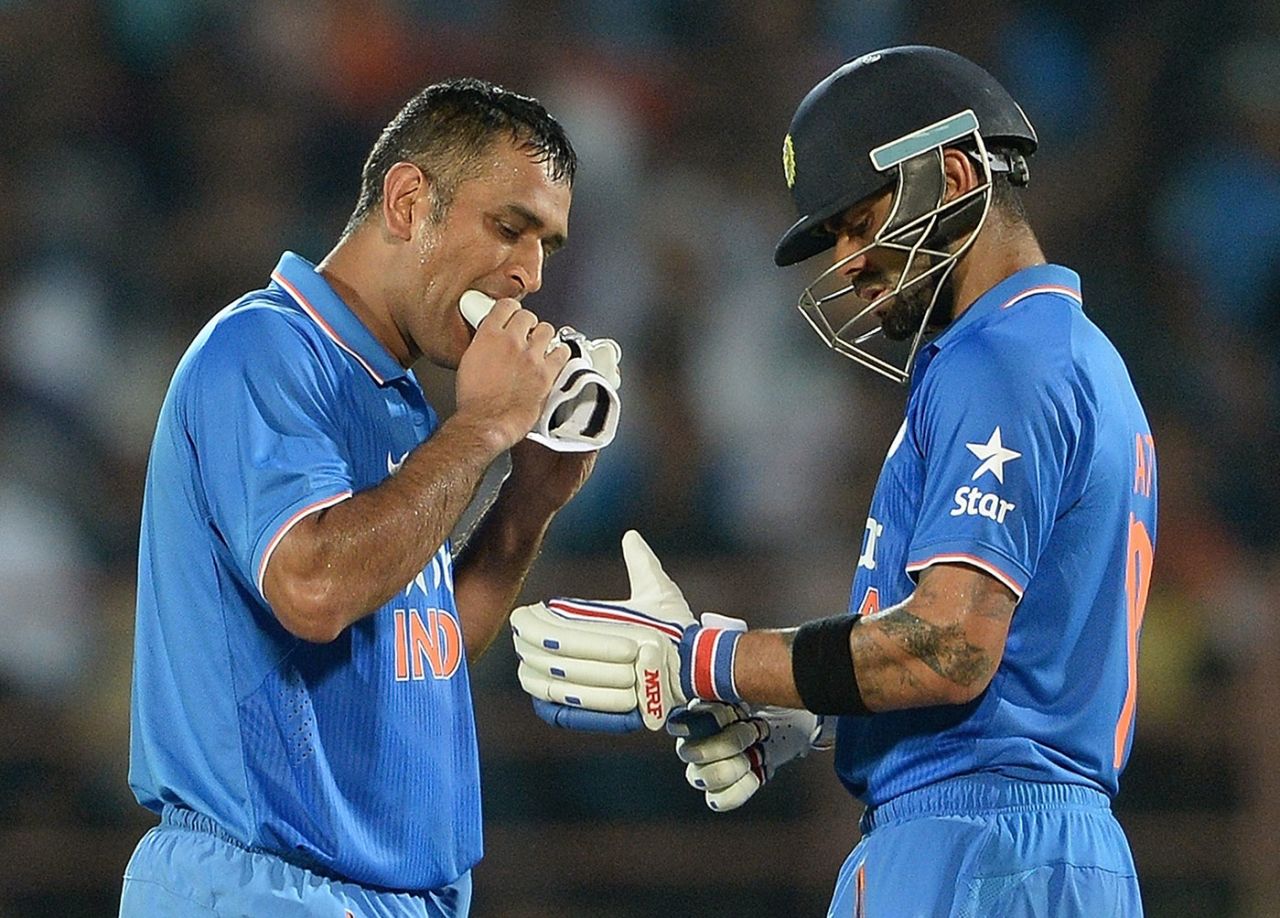 Ms Dhoni bites his glove while Virat Kohli adjusts his, India v South Africa, 3rd ODI, Rajkot, October 18, 2015