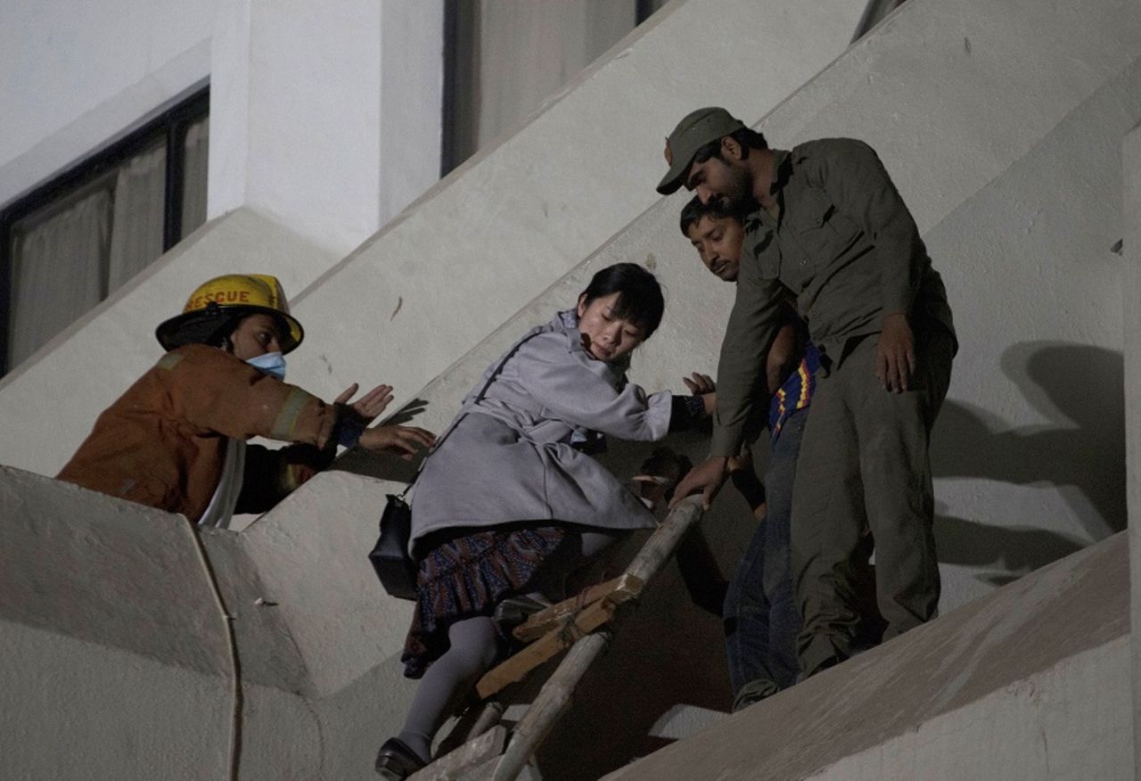 A guest at Regent Plaza Hotel is helped to safety after a fire broke out at the hotel, Karachi, December 5, 2016