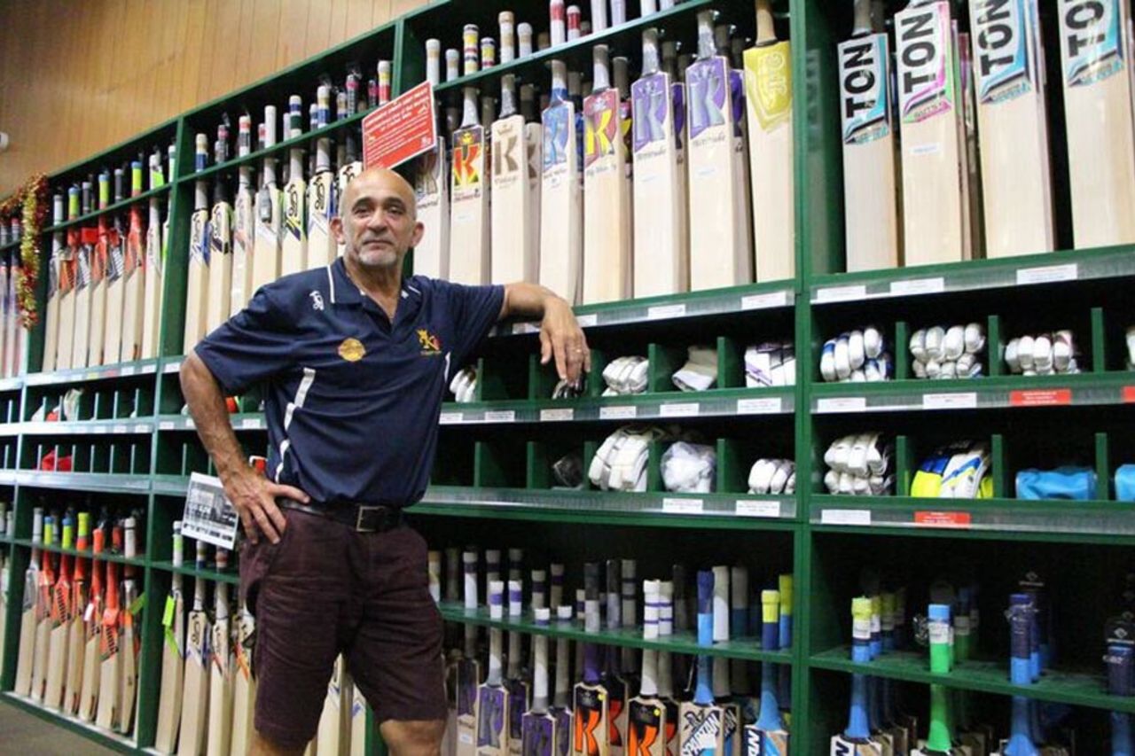 Harry Solomons poses in front of cricket equipment in his store, Sydney