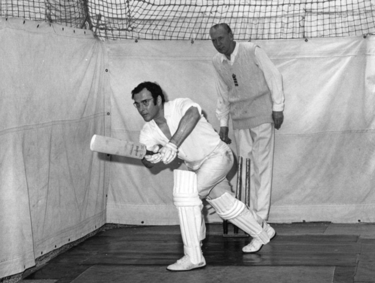 Playwright Harold Pinter bats in the nets watched by coach Alf Gover in his indoor cricket school in London, May 19, 1961
